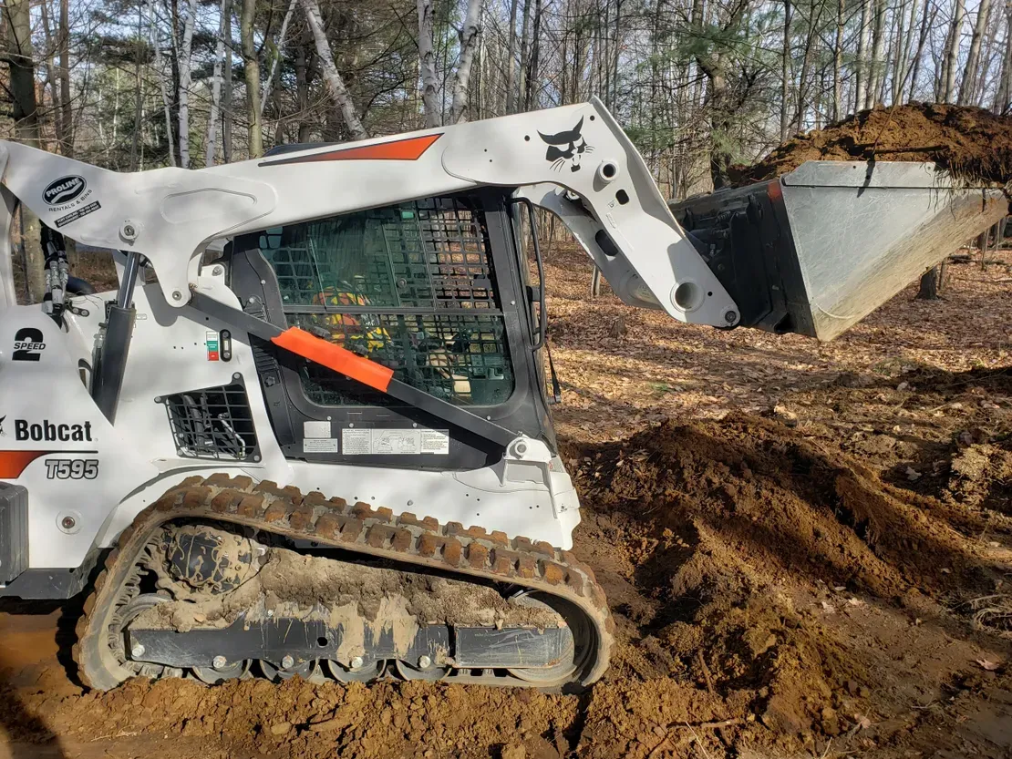 Skid steer loader moving dirt