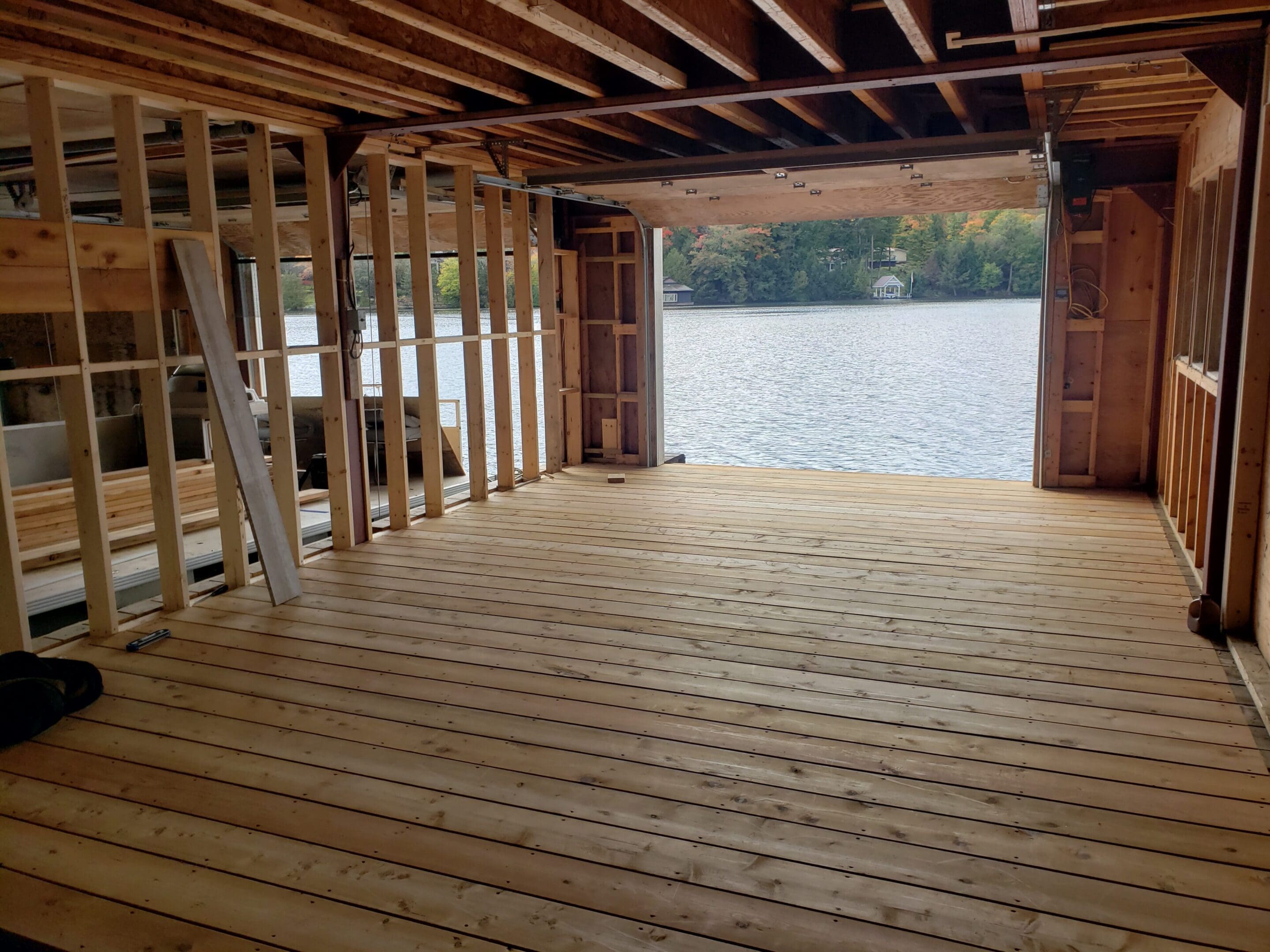 Unfinished boathouse interior overlooking calm lake