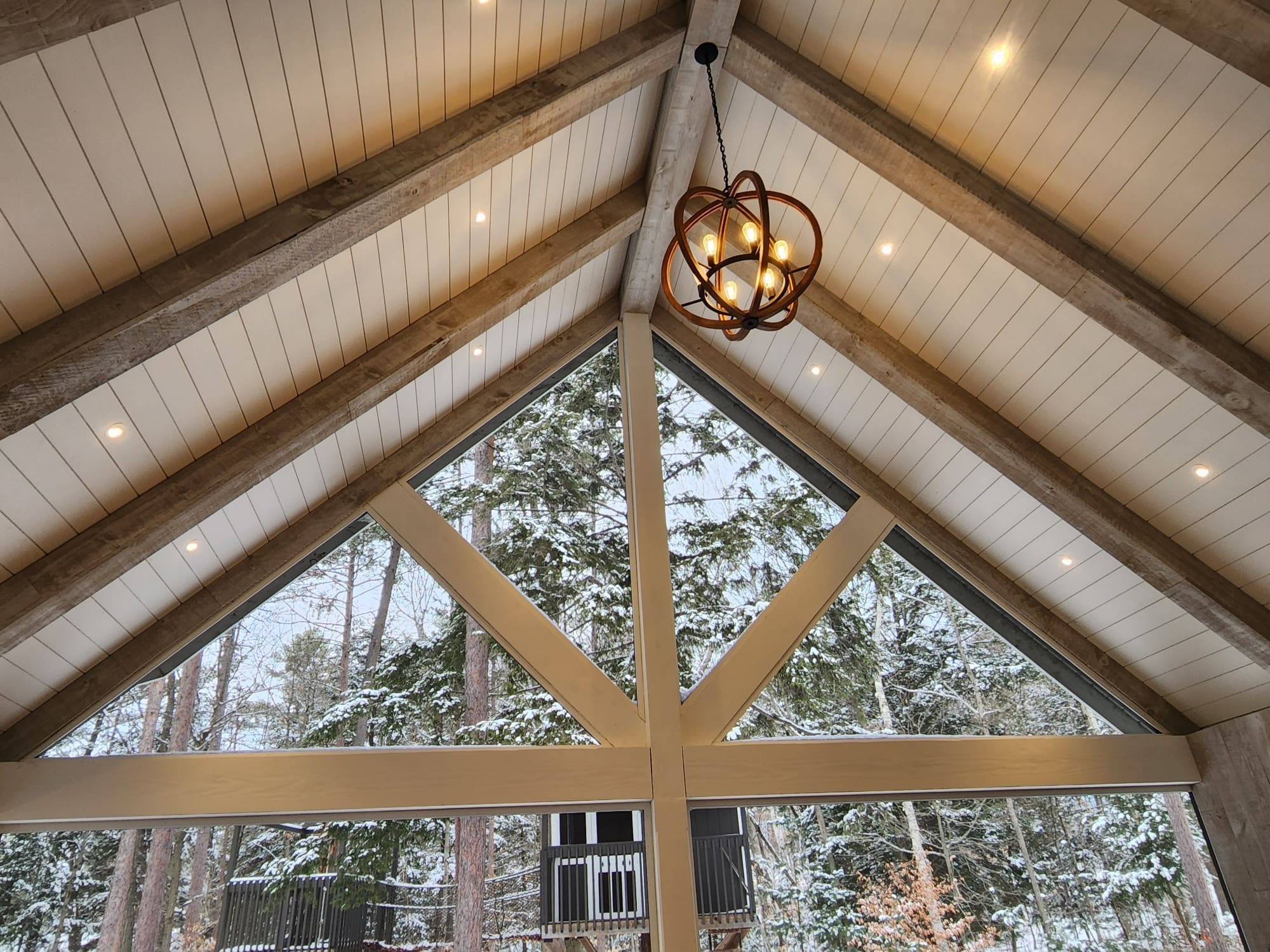 Vaulted ceiling with triangular window and chandelier