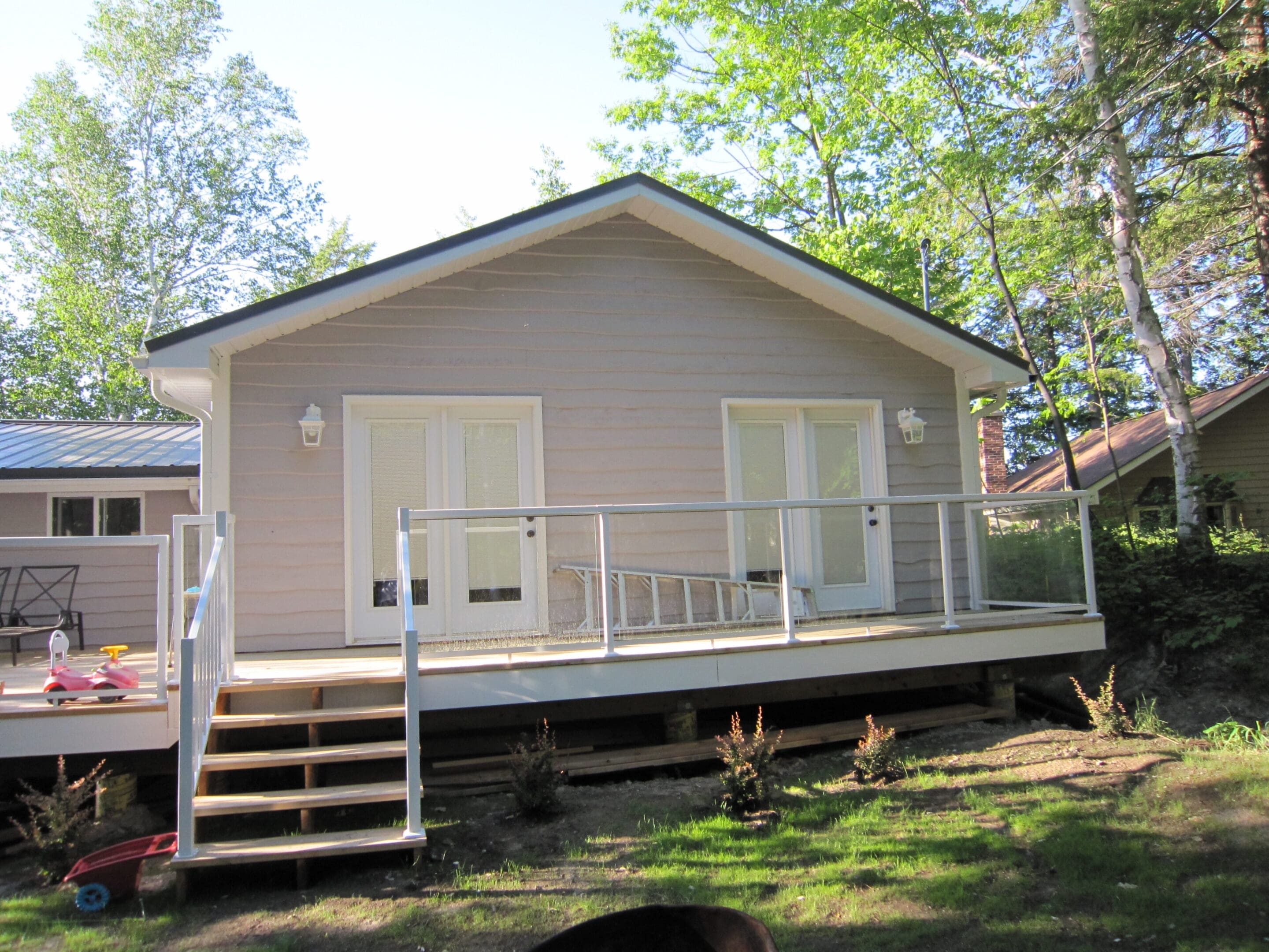 Small gray cabin with deck and stairs